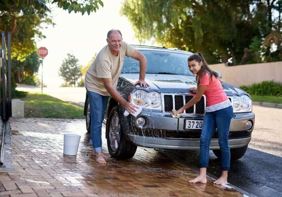 Carwash days. Portrait of a father and daughter washing a car together outside